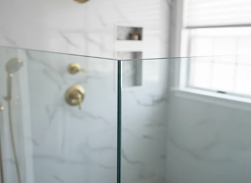 Close-up detail of the edge where two frameless glass panels meet, showing the precision of the seam and the quality of th...